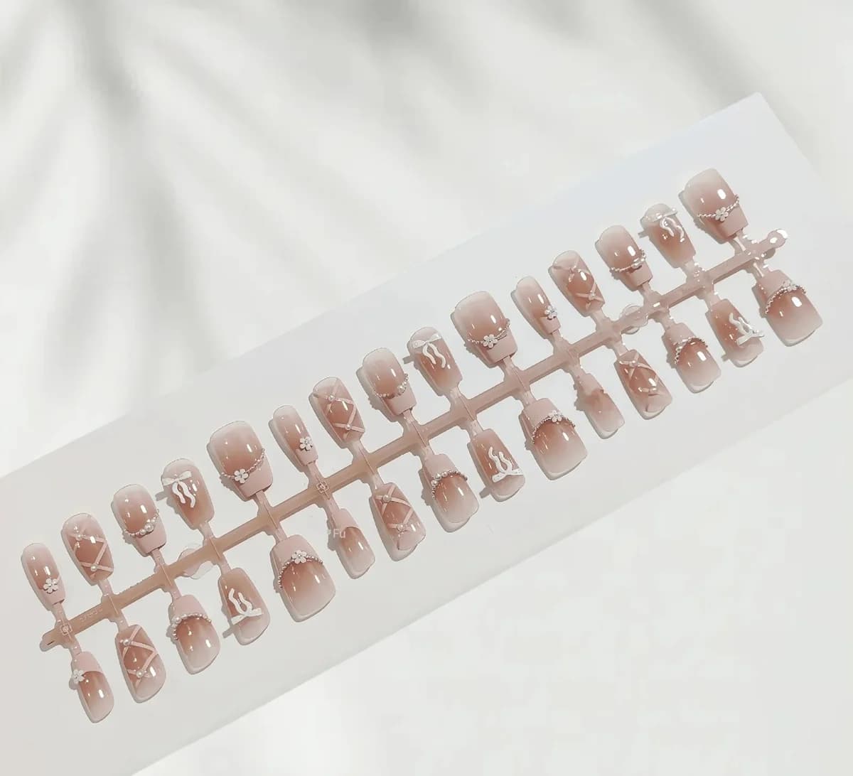 Móng tay giả French tip hồng, dáng vuông ngắn, họa tiết dây xích và nơ