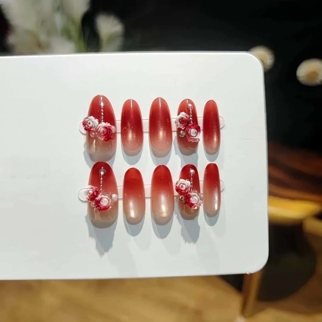 Móng tay dán mắt mèo vườn hồng, chuyển sắc đỏ nhũ, dáng oval