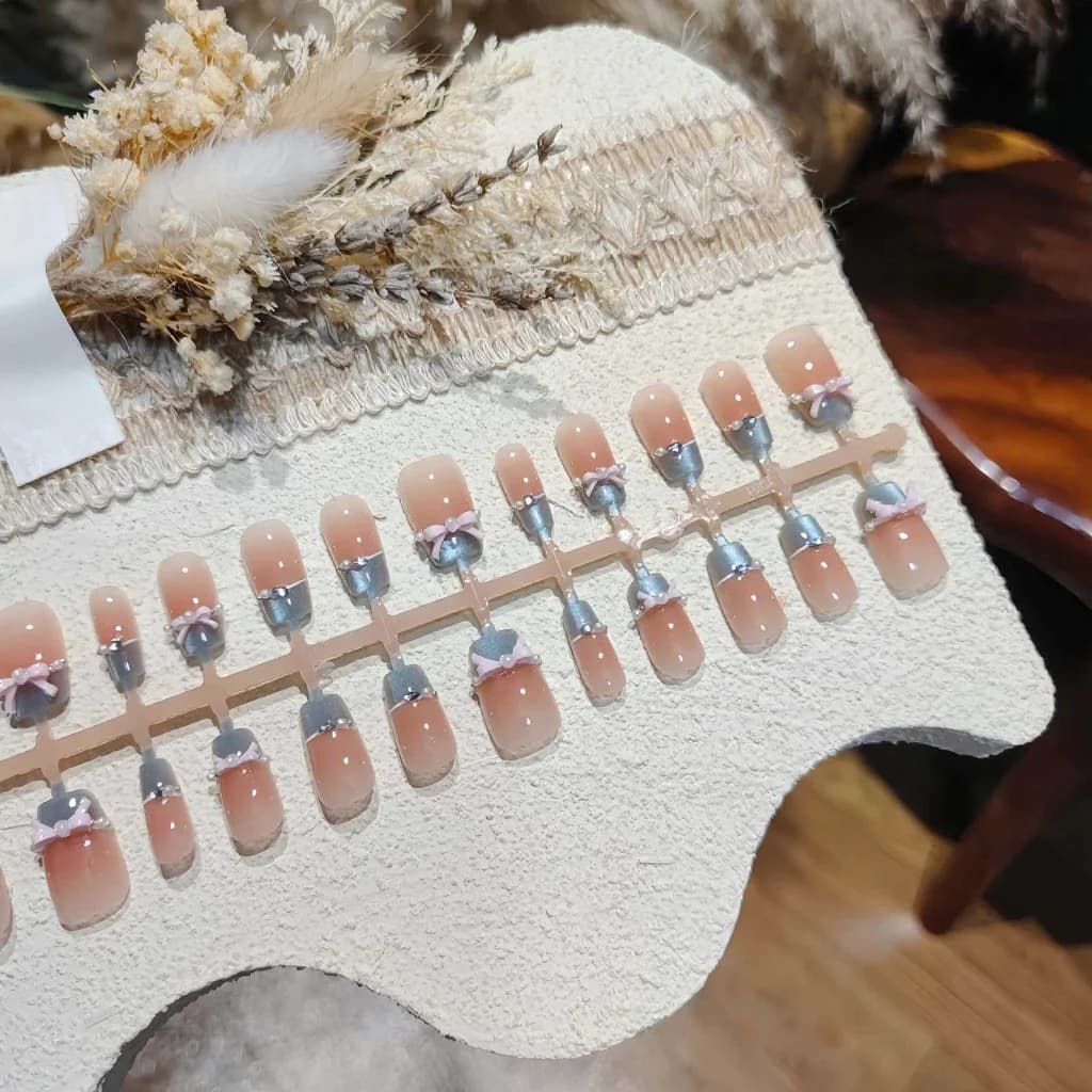 Móng tay dán mắt mèo xanh dương, nơ hồng pha lê